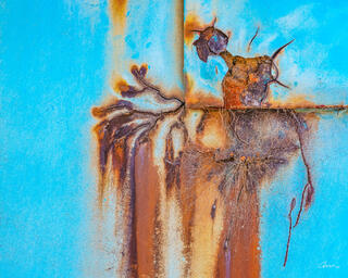 Close-up of metal door with rust patterns that looks like Poseidon and his trident.