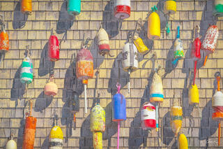 Lobster buoys line up a shack wall in a colorful display.