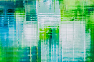 Blue, green, and white grids of color reflecting on lake surface