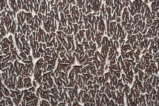 Close-up of textured pattern of brown on white that looks like chocolate shavings on buttercream icing.