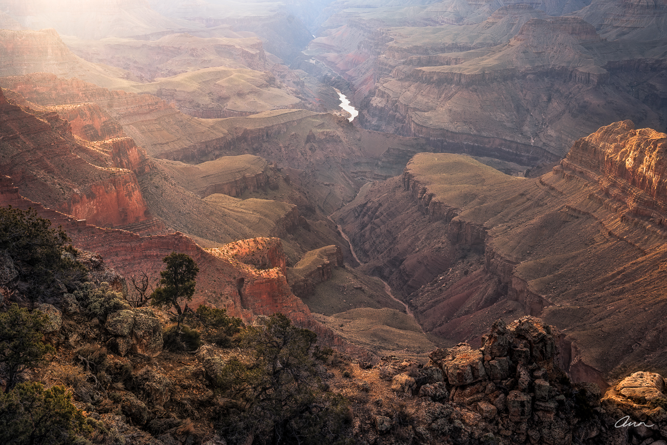 Sunset light giving glow to plateaus in Grand Canyon and Colorado River below gets a touch of light too.
