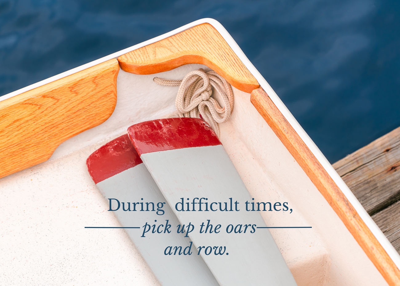 A photo of two oars in a rowboat and a quote about difficult times.